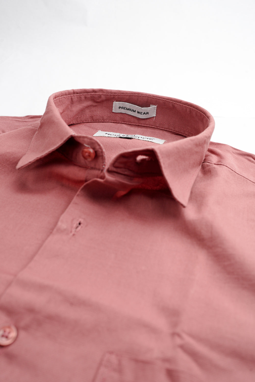 Close-up of a Red wood colour Rodi Machine shirt with a collar and buttons, featuring a brand label.