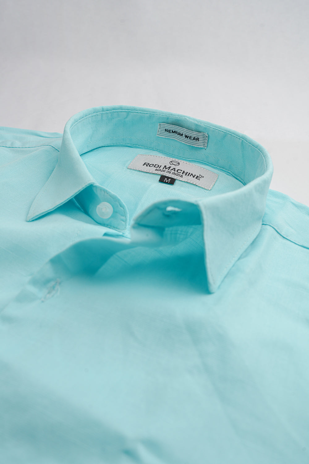 Aqua Blue colour Rodi Machine shirt with collar and brand label on a light gray background
