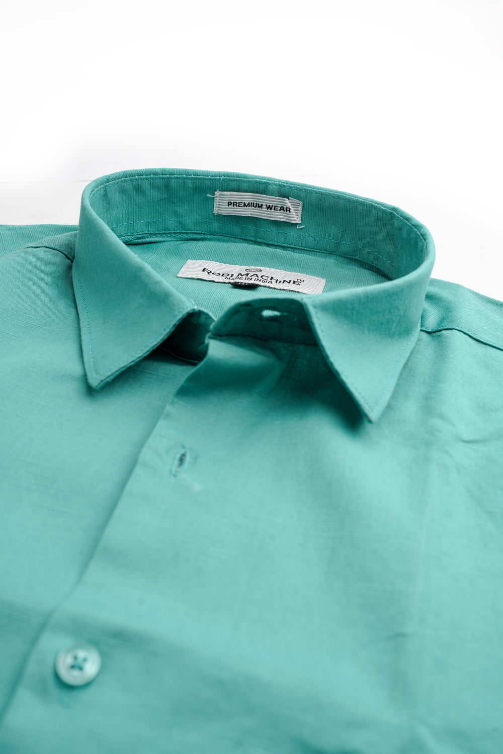 Close-up of a Cian colour Rodi Machine shirt with collar and button details on a white background