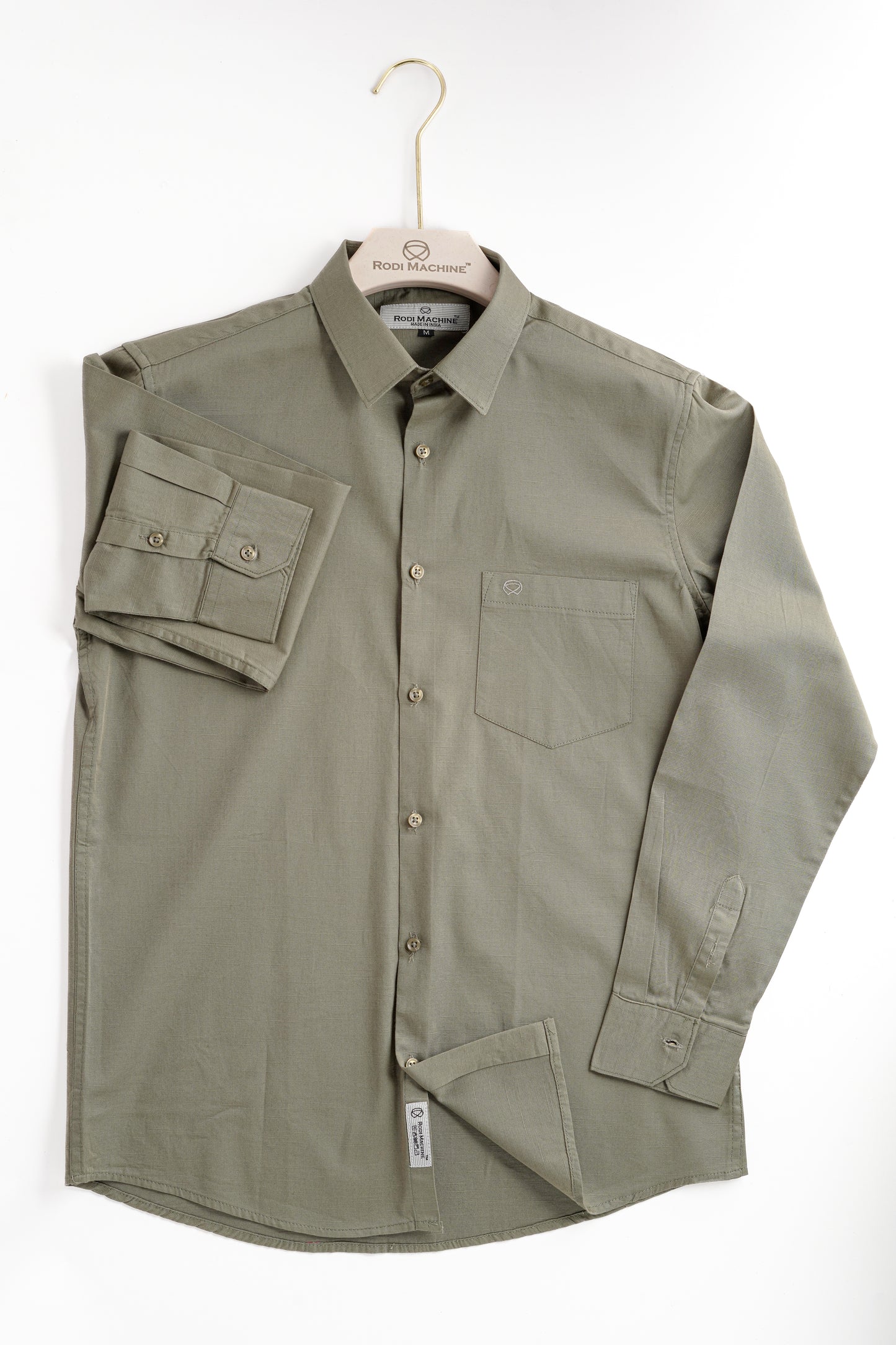 Olive Green Rodi Machine shirt on a hanger against a white background